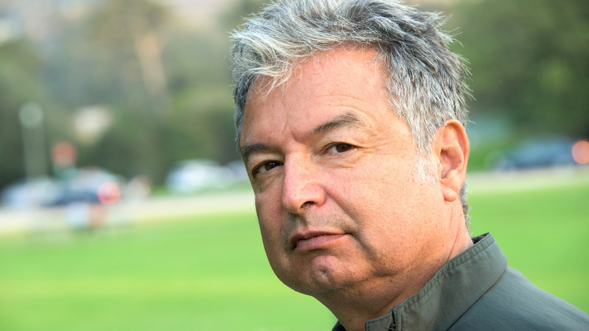 Middle aged man in a park with windblown hair