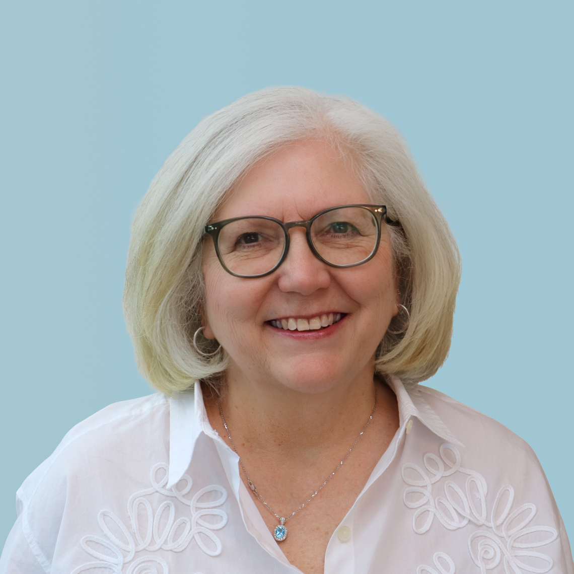 Headshot of Annette Roberts in glasses and a white collared shirt