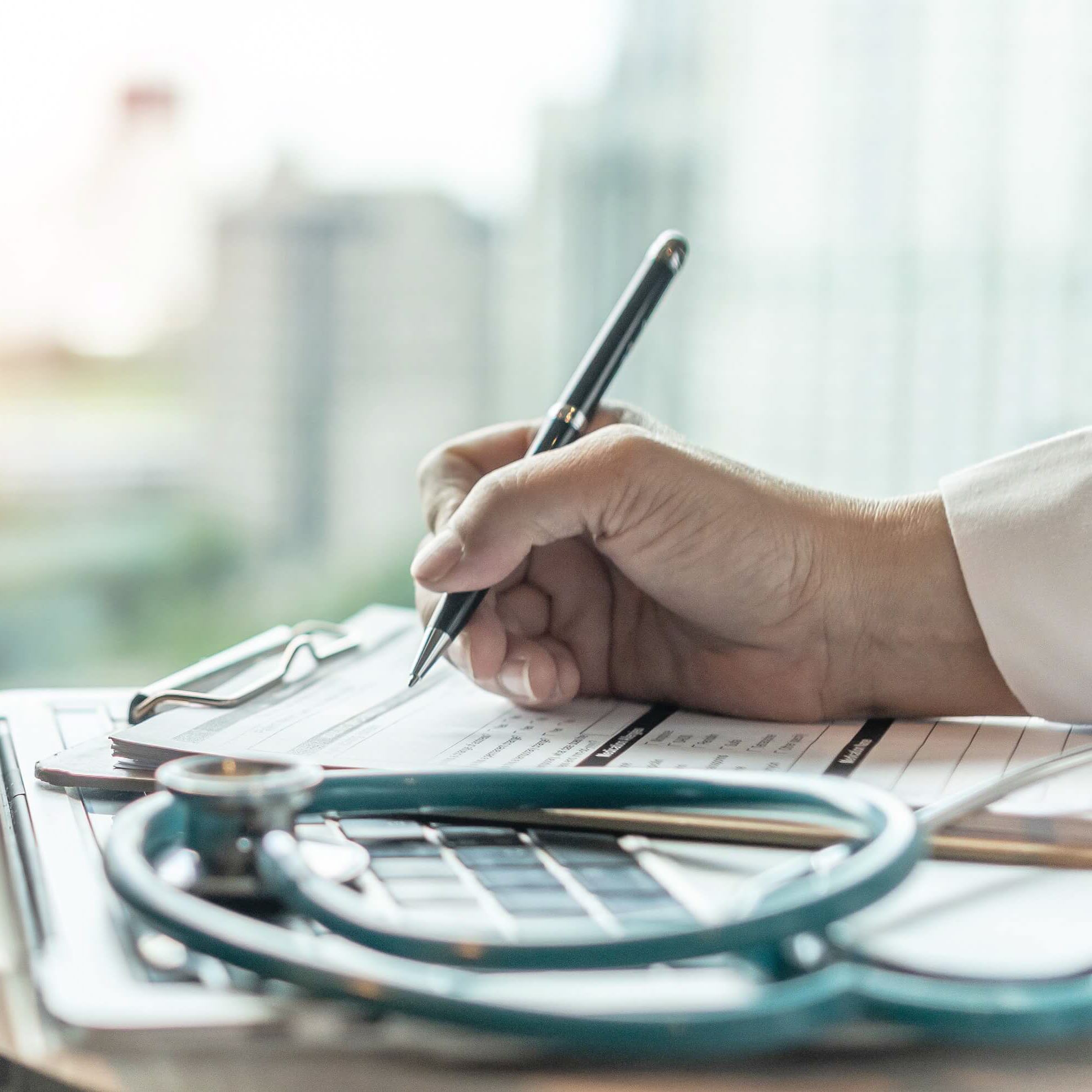 doctor hand writing with a pen on a clipboard